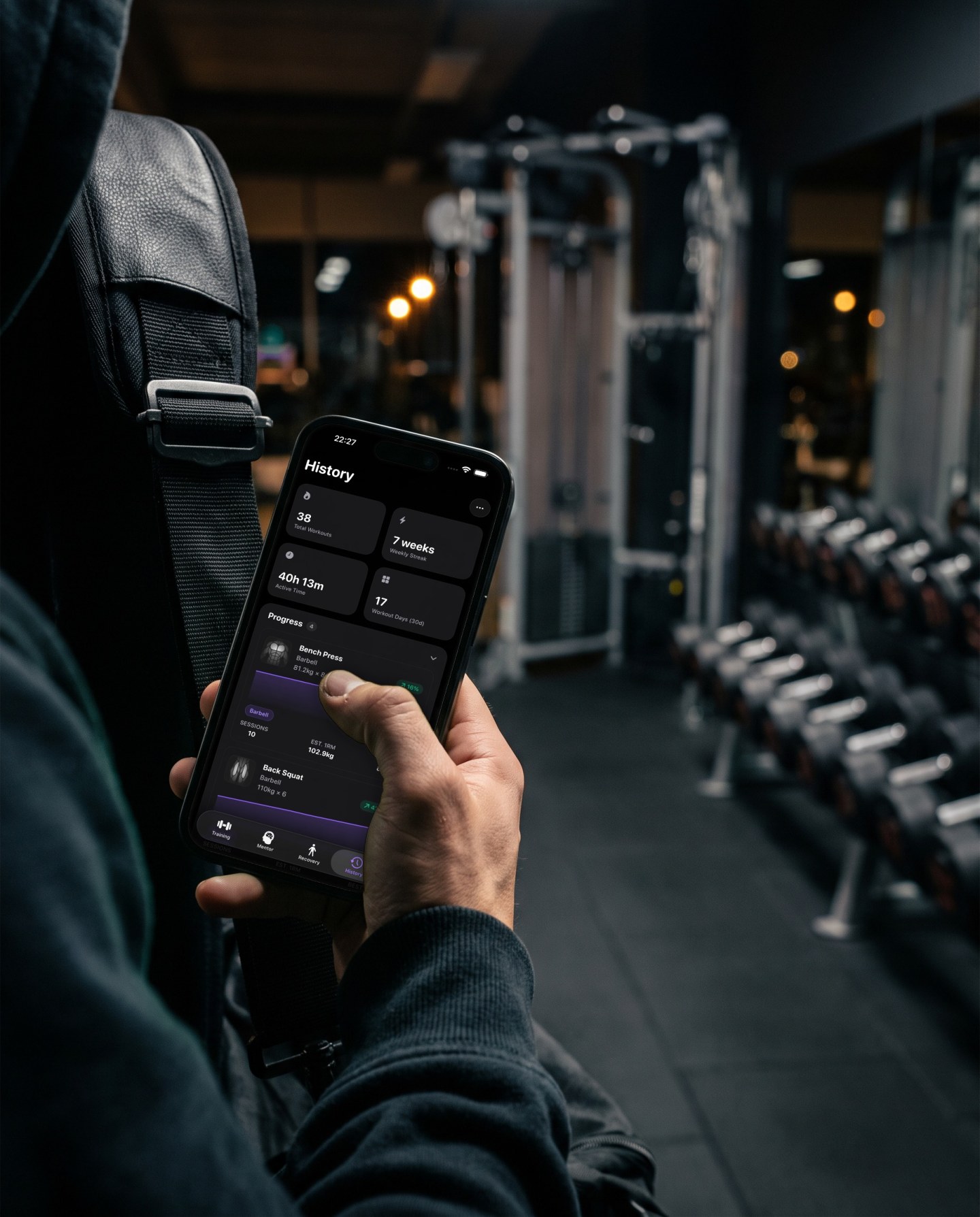 Leaving the gym with a bag over the shoulder, a thumb scrolls the Reps History screen showing workouts, a seven week streak and progress per exercise