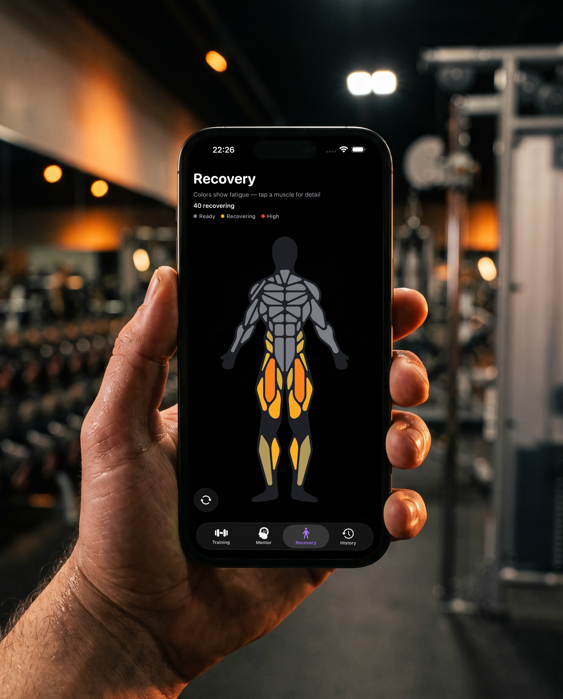 A sweaty hand holds the phone in front of a dim gym. The Reps recovery muscle map shows which muscles are still recovering